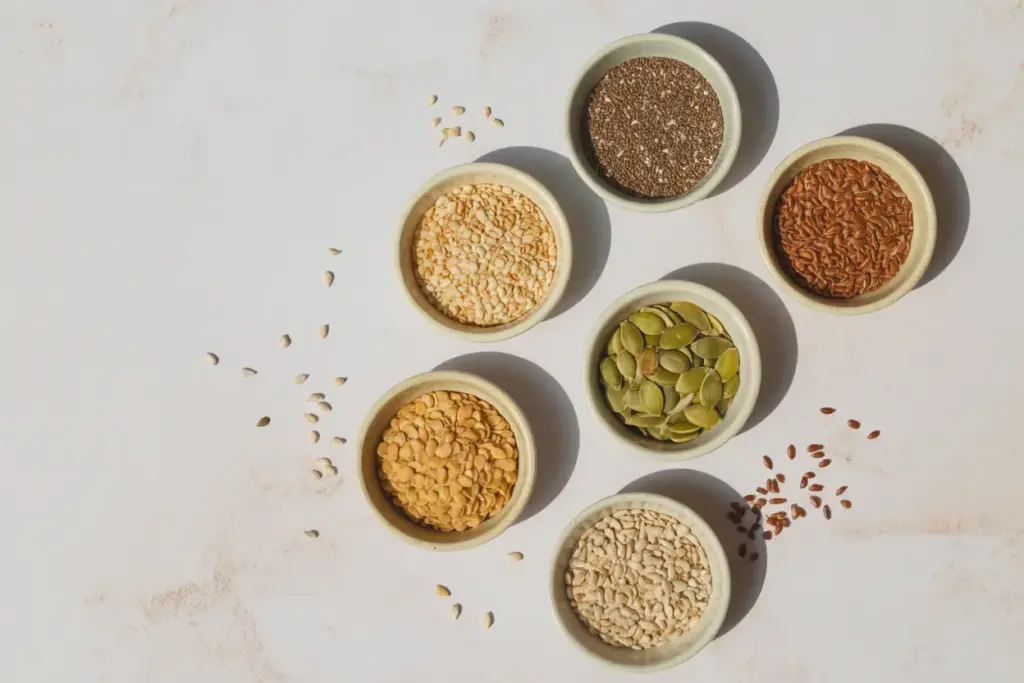 A vibrant flat lay of the best seeds for weight loss, including nutrient-packed flax, chia, pumpkin, and sunflower seeds, arranged in small bowls on a clean background.