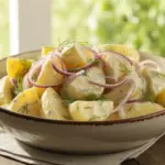 A creamy bowl of classic 4-ingredient potato salad, made with tender potatoes, mayonnaise, and onions, served as a summer side dish.